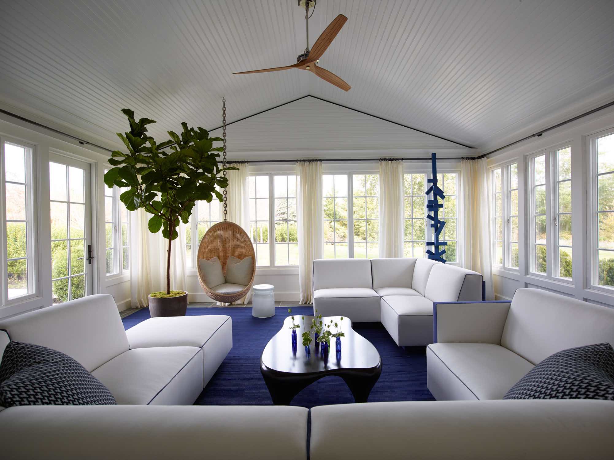 Honed Thassos marble and Lapis Lazuli stone wall tile create a striped pattern in this Hamptons powder room designed by Carol Egan.  Handblown Glass Henry Pendants by Waterworks flank a decorative mirror with rope and nickel accents designed by Thomas Boog, low profile Henry Faucet by Waterworks can be seen on the oak and white marble vanity.