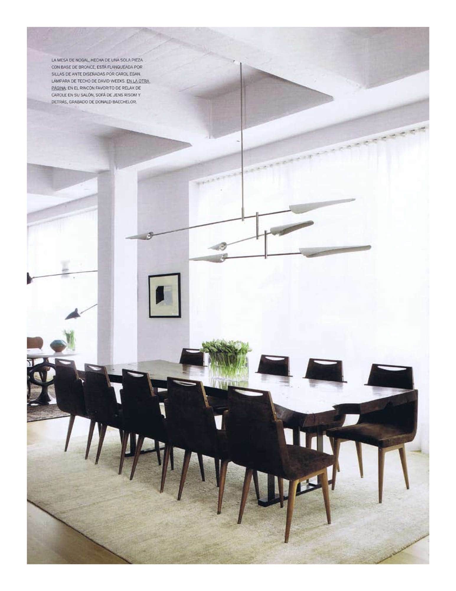 Photograph of a dining room with a large dining table in walnut by Hudson Furniture, custom dining chairs design by Studio Carol Egan in royal suede in pitch brown by Edelman Leather and Sarus three-tier chandelier by David Weeks.