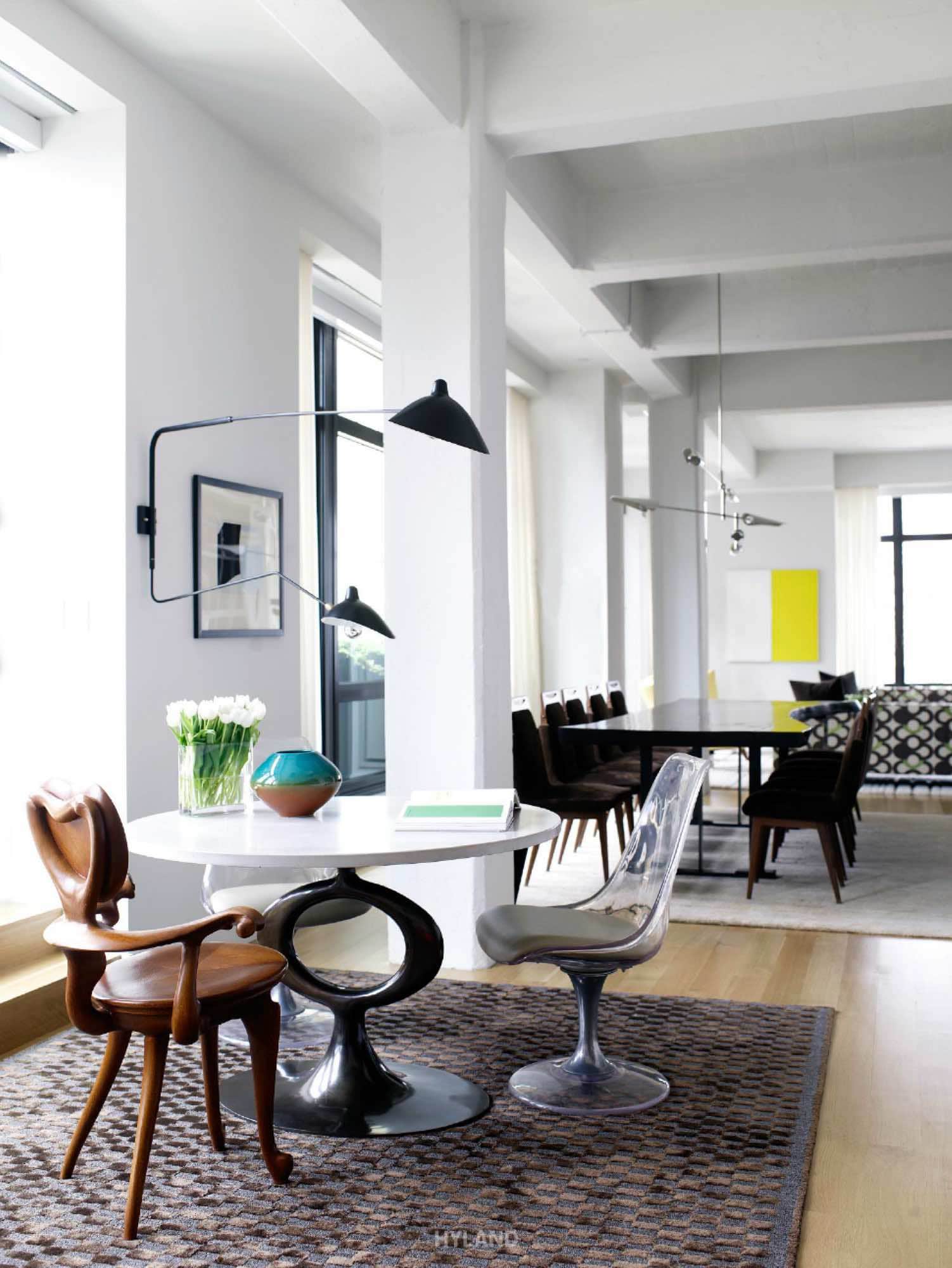 Shown in the image, designed by Carol Egan Interiors, is an elliptical table which has a poured concrete top and bronze base.  A pair of shapely Lucite chairs and an unusual Gaudi chair are complementary.  Tai Ping sisal and silk rug.
